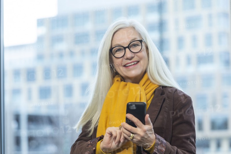 Smiling businesswoman with smartphone in office