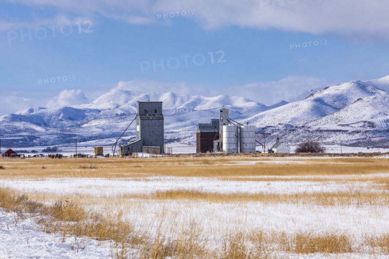 Farm in snowy field by mountains