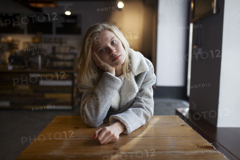 young woman sitting at cafe table
