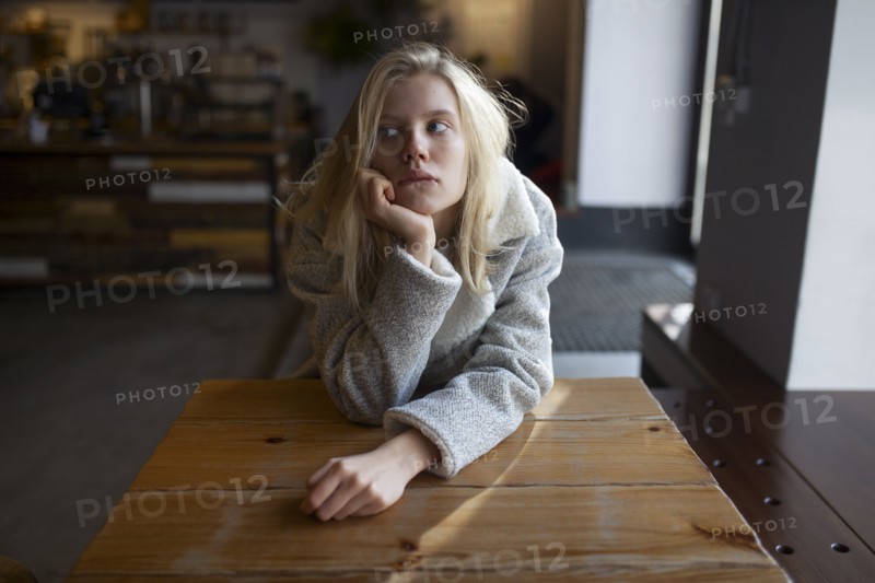 young woman sitting at cafe table