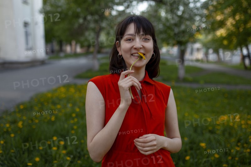 Smiling young woman holding flower