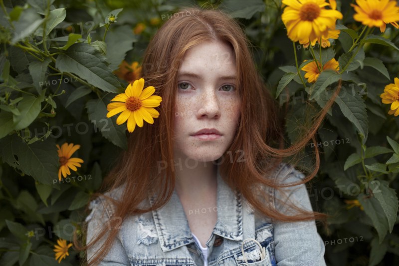 Teenage girl by bush with orange flowers