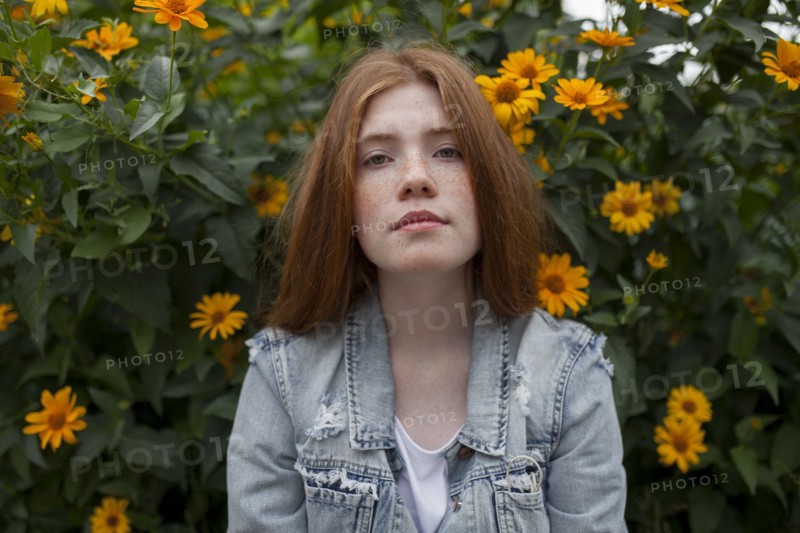 Teenage girl by bush with orange flowers