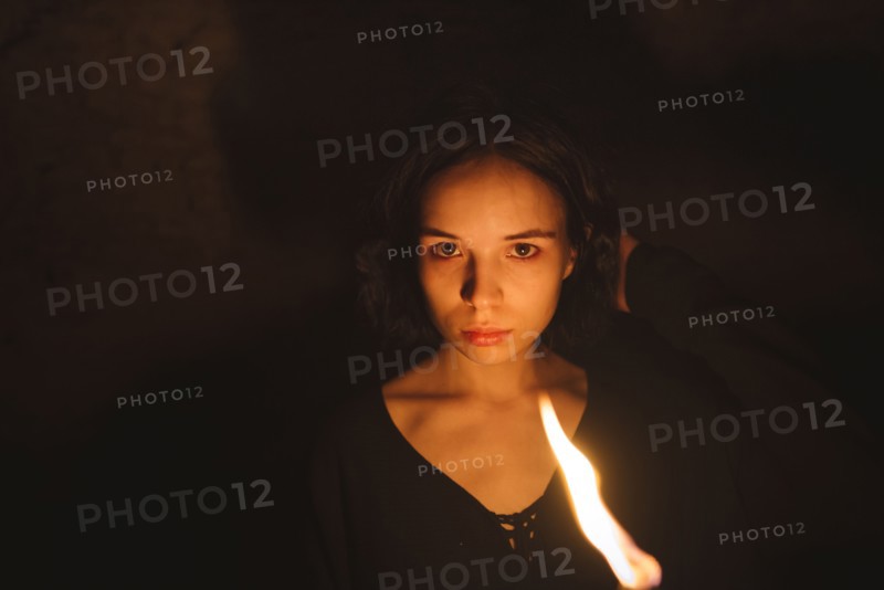 young woman with flaming torch at night