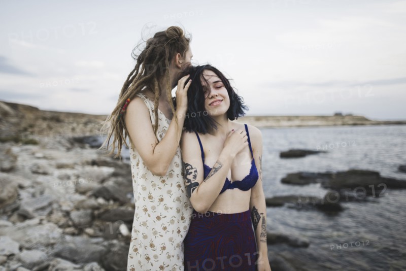 young women standing together on beach