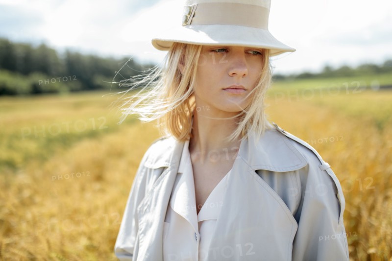 young woman with fedora in wheat field