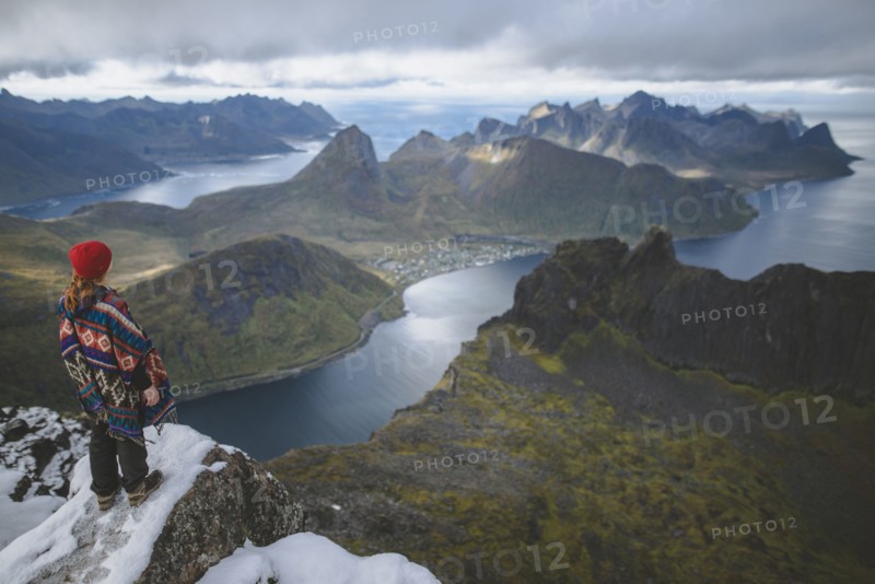 young woman in red hat and sweater on snowy mountain