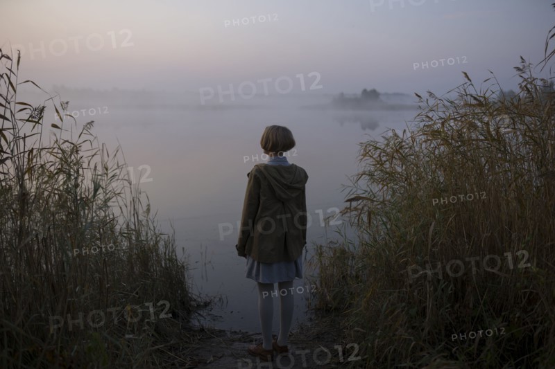 young woman by lake at sunset