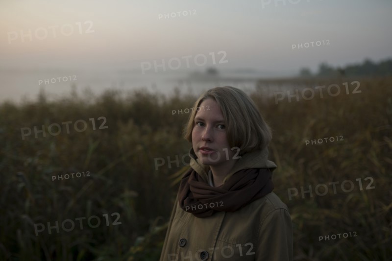 young woman in field at sunset
