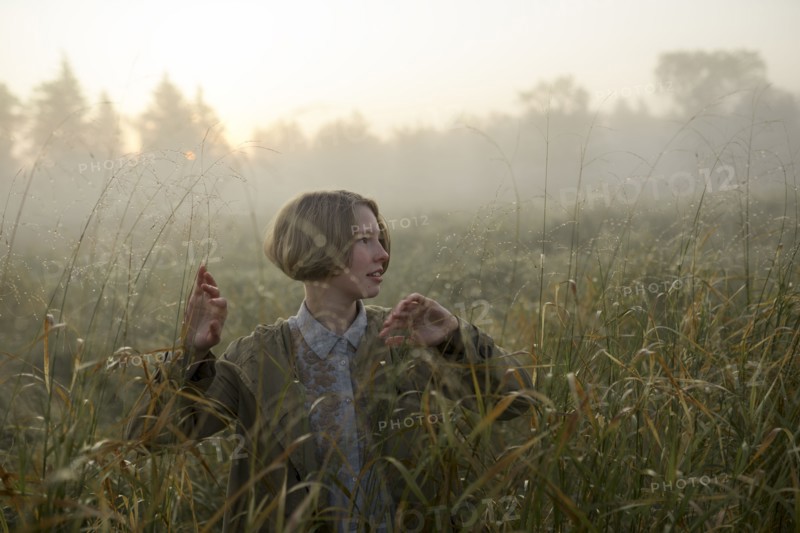young woman in field of long grass
