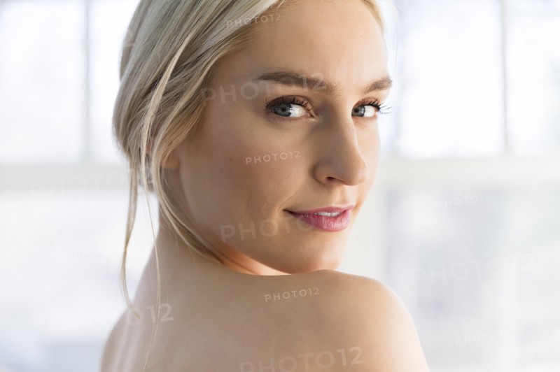 Portrait of woman looking over her bare shoulder