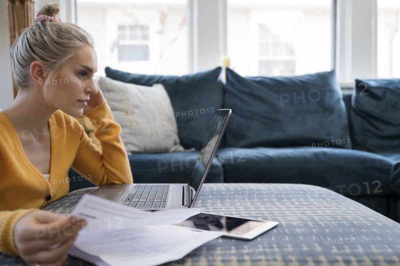 Woman working with laptop and paperwork