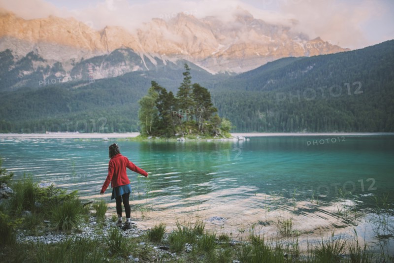 Germany, Bavaria, Eibsee, Young woman walking at shore of Eibsee lake in Bavarian Alps