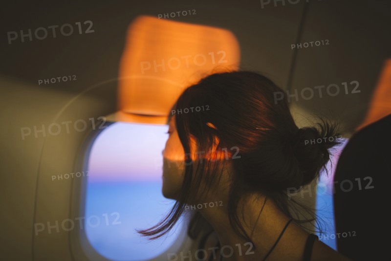 Portrait of young woman in plane illuminated with sunset light
