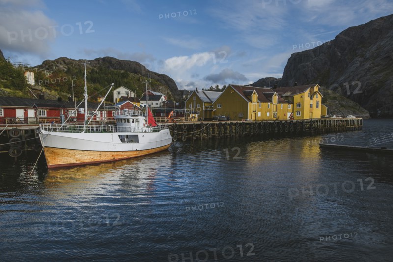 Norway, Lofoten Islands, Nusfjord, Fishing boat in dock in traditional fishing village