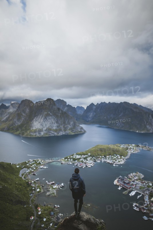 Norway, Lofoten Islands, Reine, Man looking at fjord from Reinebringen mountain