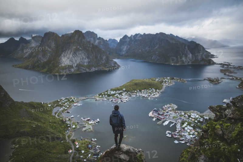 Norway, Lofoten Islands, Reine, Man looking at fjord from Reinebringen mountain