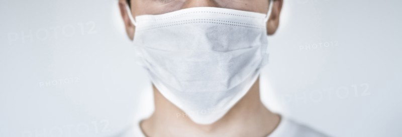 Studio shot of teenage boy (16-17) wearing protective mask