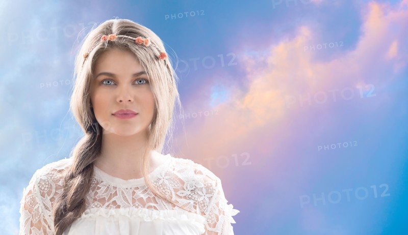 Woman wearing flower crown against overcast sky