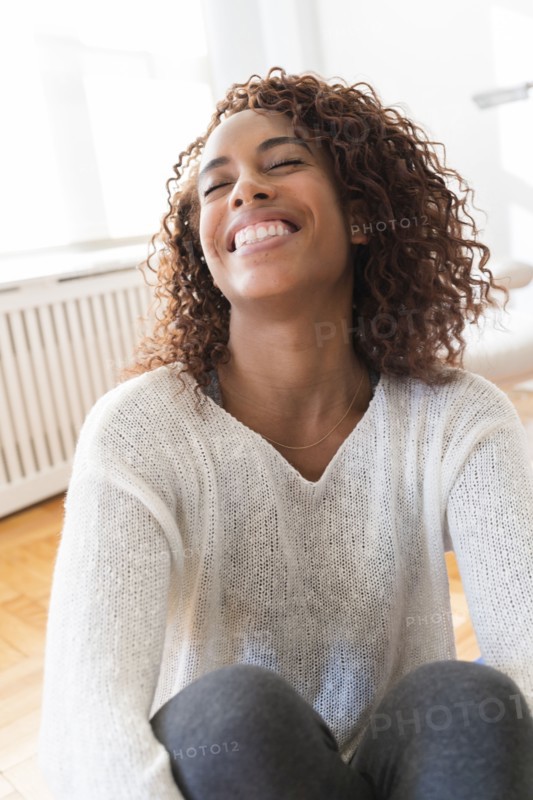 Smiling woman hugging her knees