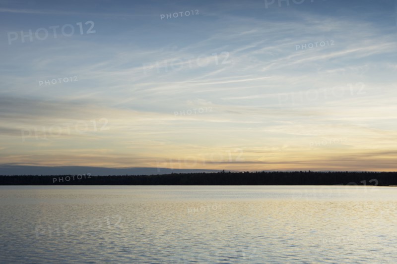 Silhouette of trees and lake at sunset