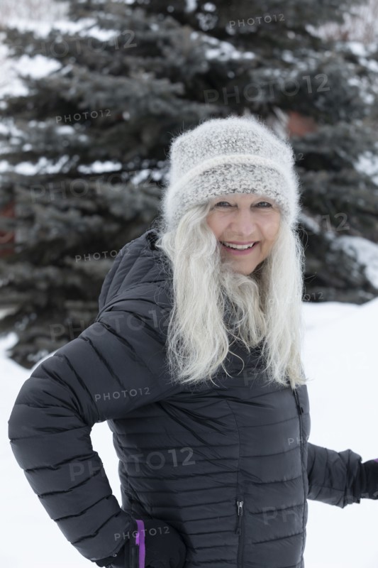 Smiling woman wearing hat and jacket in snow