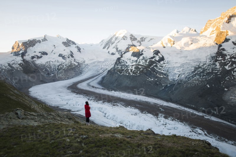 Woman standing on rock by Gorner Glacier in Valais, Switzerland