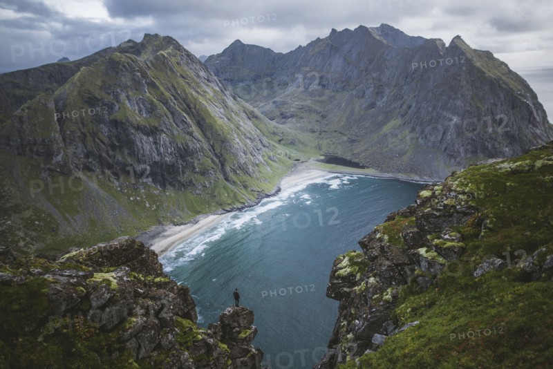 Man standing on cliff at Ryten mountain in Lofoten Islands, Norway