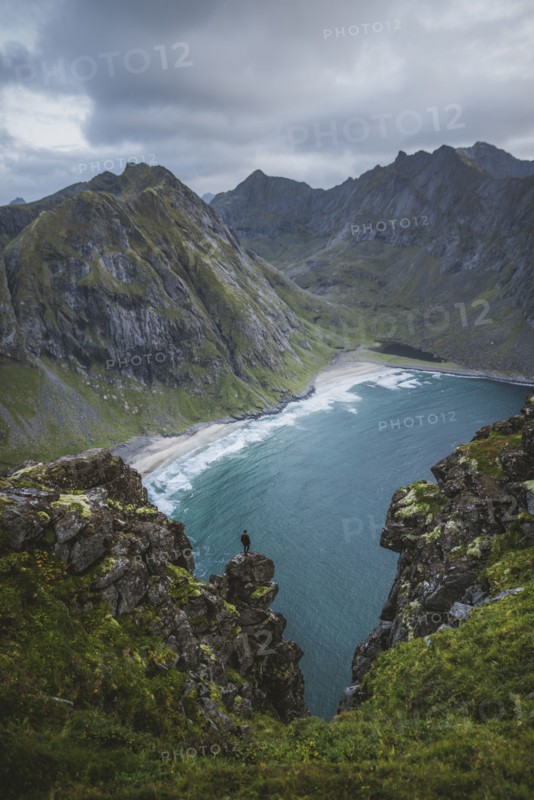 Man standing on cliff at Ryten mountain in Lofoten Islands, Norway