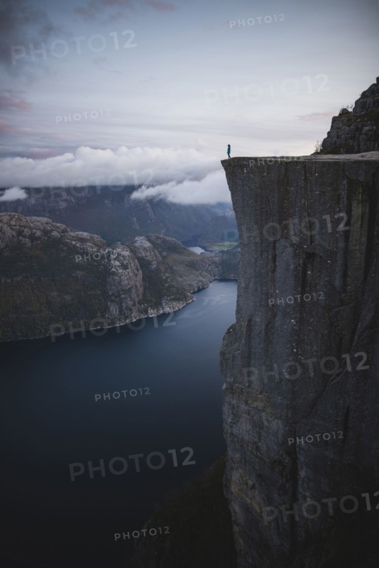 Person standing on Preikestolen cliff in Rogaland, Norway