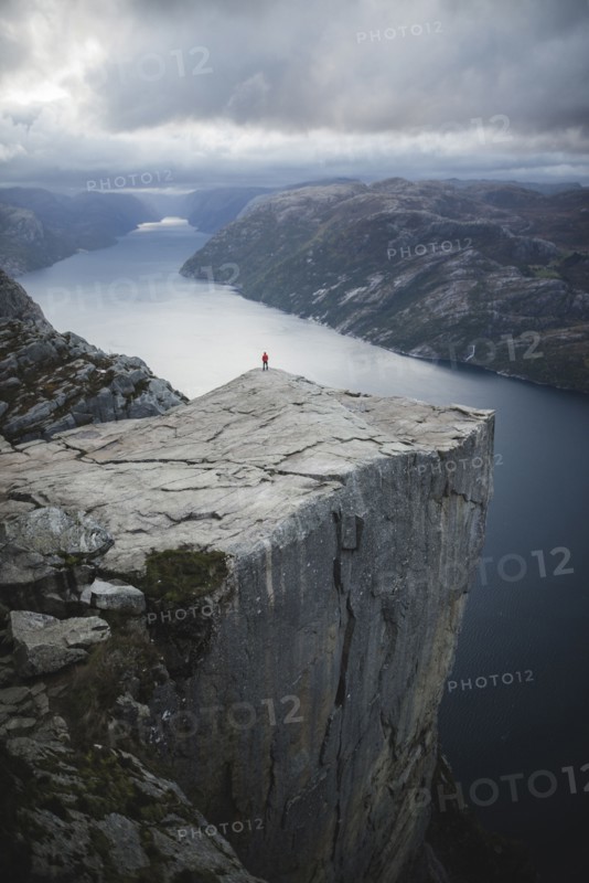 Person standing on Preikestolen cliff in Rogaland, Norway
