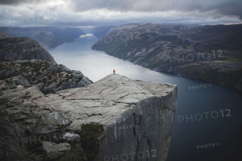 Person standing on Preikestolen cliff in Rogaland, Norway