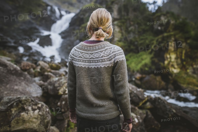 Woman wearing sweater by Latefossen waterfall in Vestland, Norway