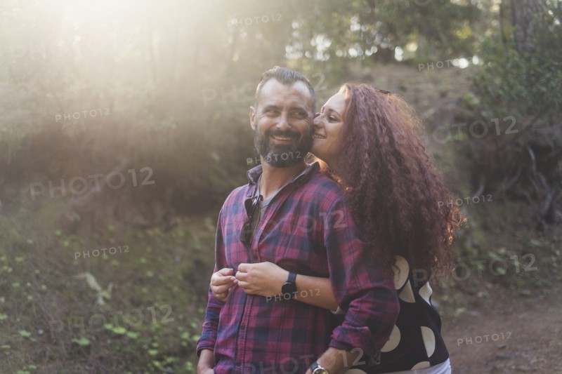 Smiling couple embracing in forest