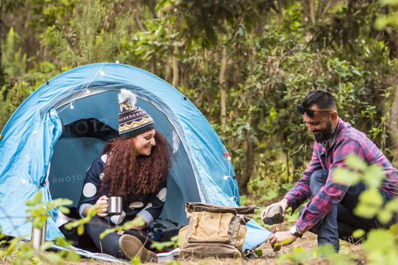 Man using rock to hammer tent peg
