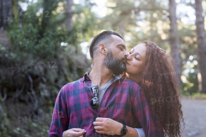 Couple kissing by trees