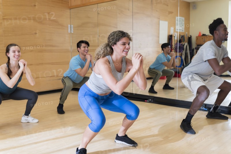 Men and women exercising in workout class