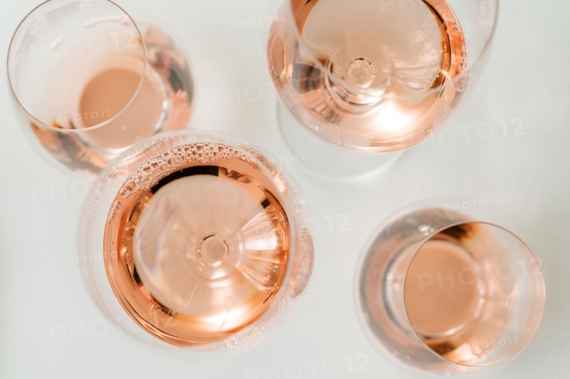 Glasses of rose wine on white background