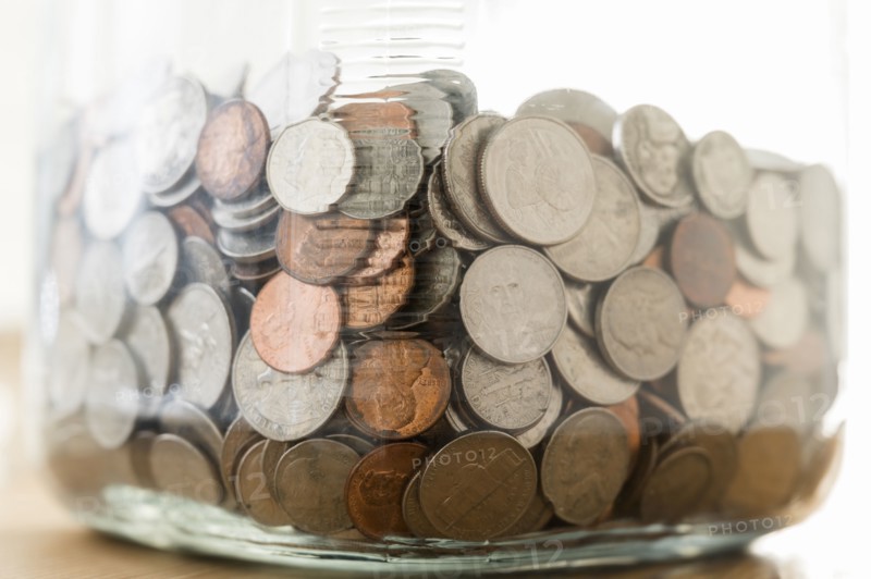 Close up of coins in large jar