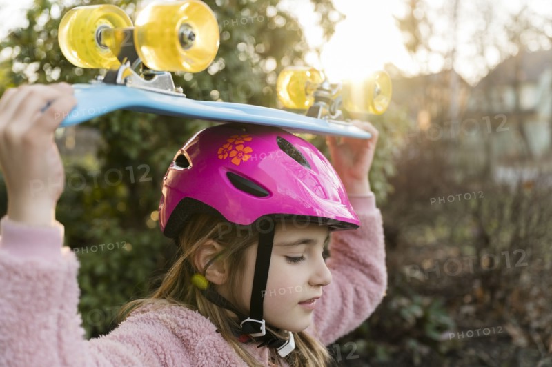 Girl carrying skateboard on head