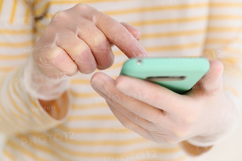 Hands in gloves using smart phone
