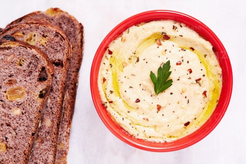 Overhead view of bowl of hummus and slices of bread