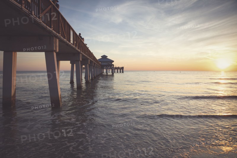 USA, Florida, Fort Myers Beach, Pier in sea at sunset