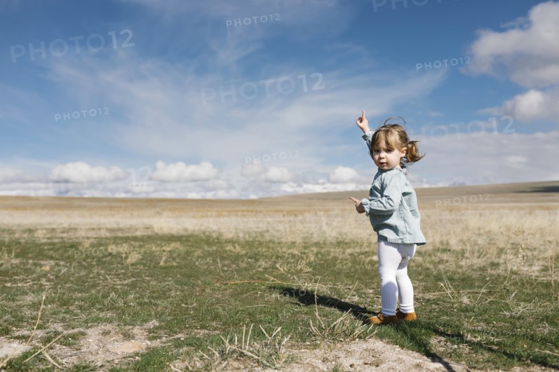 Girl (2-3) pointing towards sky