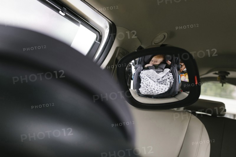 Reflection of baby boy (2-3 months) in car mirror