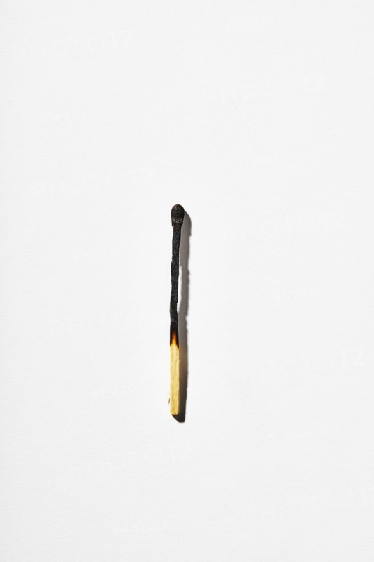 Burnt matchstick on white background