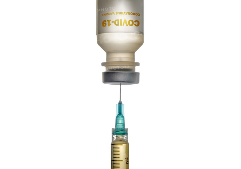 Studio shot of Covid-19 vaccine and syringe on white background