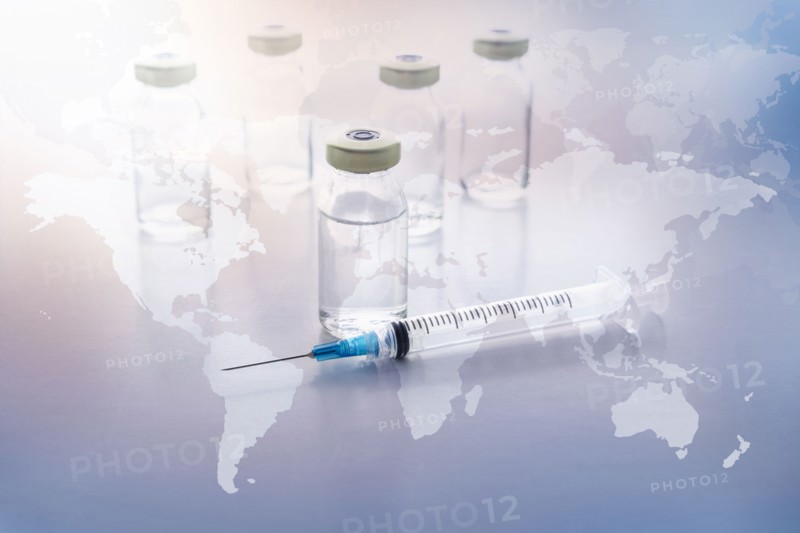 Vials and syringe with world map in background