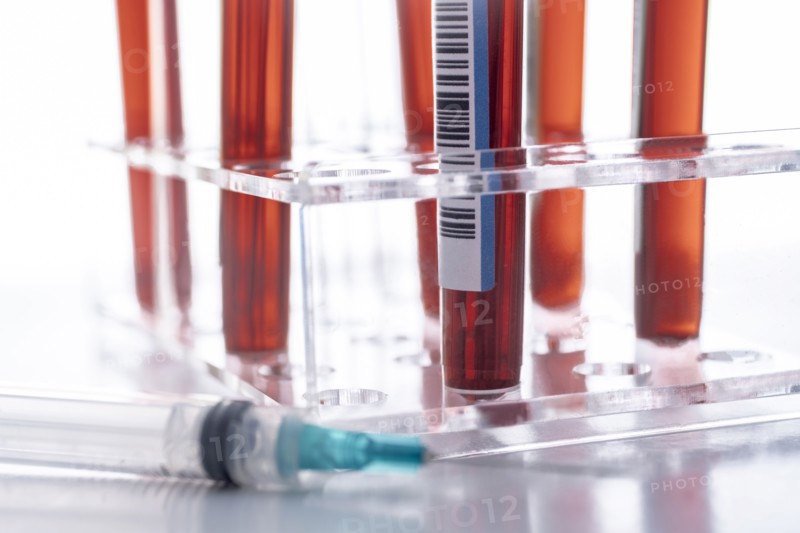 Studio shot of Covid-19 blood samples in test tube rack and syringe