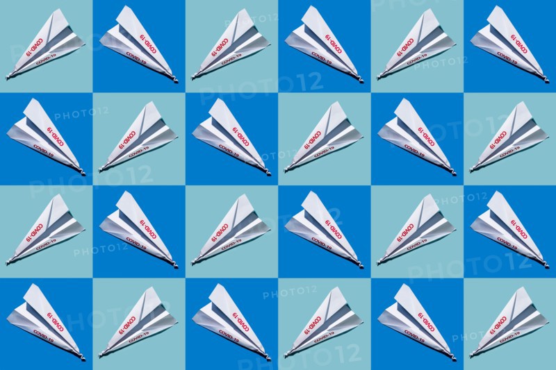 Studio shot of paper planes with Covid-19 sign